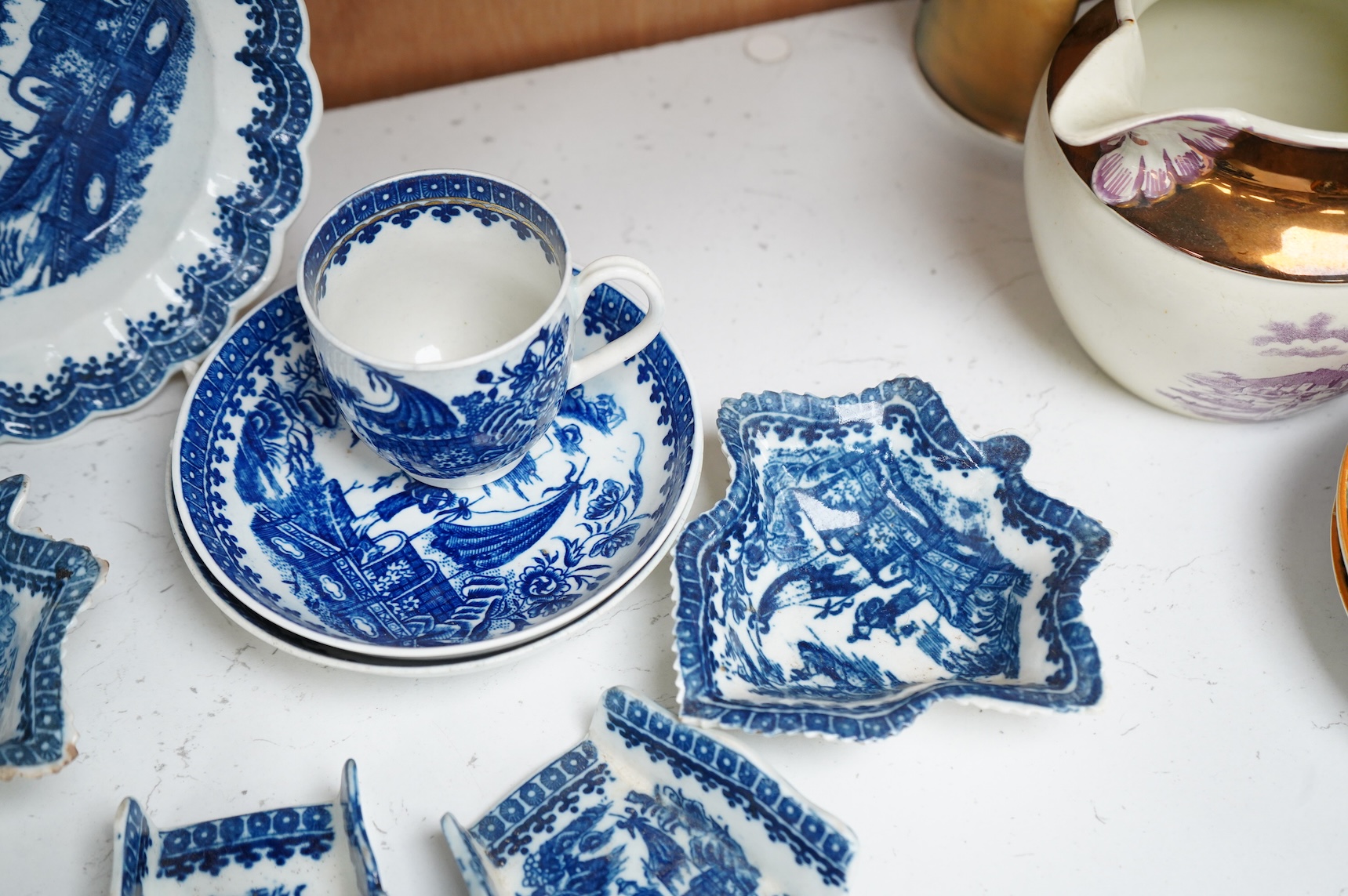 A group of 18th century Worcester or Caughley blue and white ‘Fisherman and Cormorant’ pattern wares; two asparagus dishes, three leaf pickle dishes, a cup and two saucers and a large dish- 18cm diameter (9).